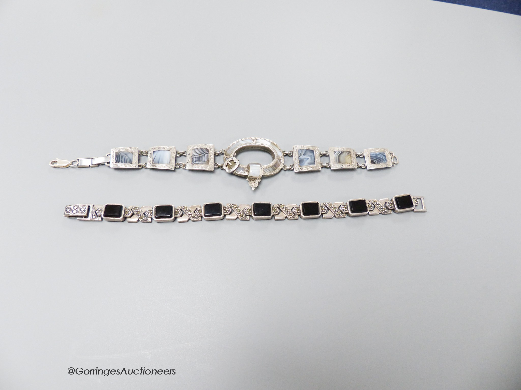 A 925 white metal and agate set bracelet, 19cm and a white metal, black onyx and marcasite set bracelet.